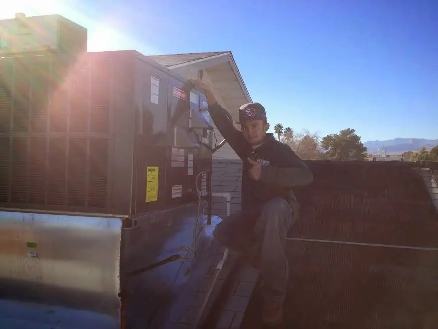 HVAC technician performing AC Tune-Up on a rooftop unit in Willow Oak